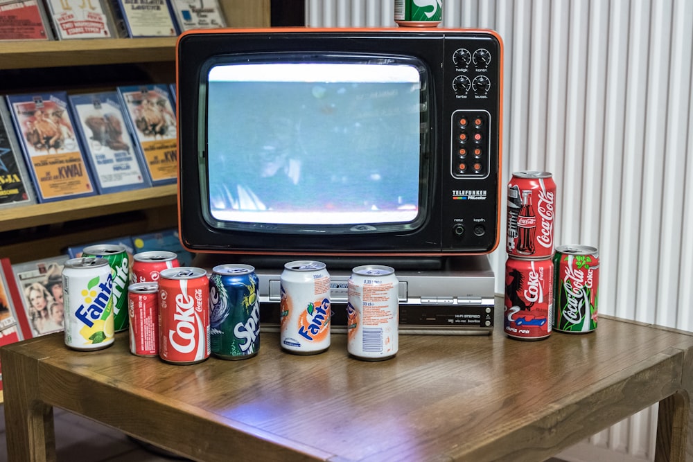 Televisor CRT negro encendido junto a una botella de plástico blanca