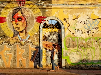 a person standing in front of a building with graffiti on it