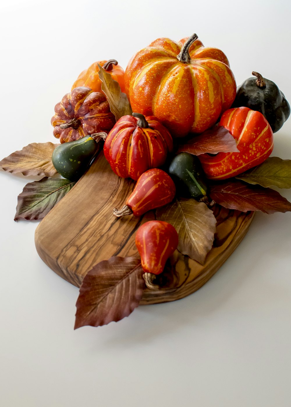 orange and green pumpkin on brown wooden round plate