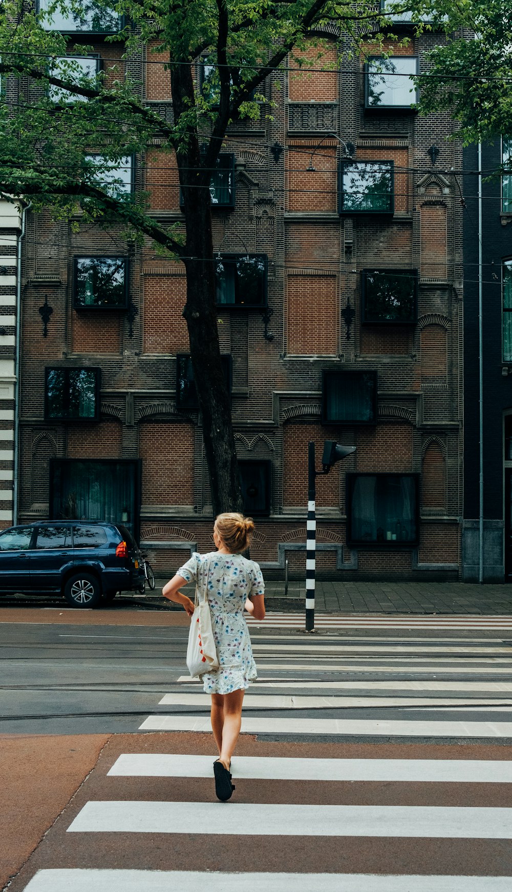 낮 동안 보행자 차선을 걷고 있는 하얀 드레스를 입은 여자