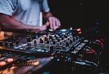 person in gray shirt playing audio mixer