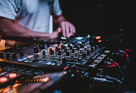 person in gray shirt playing audio mixer
