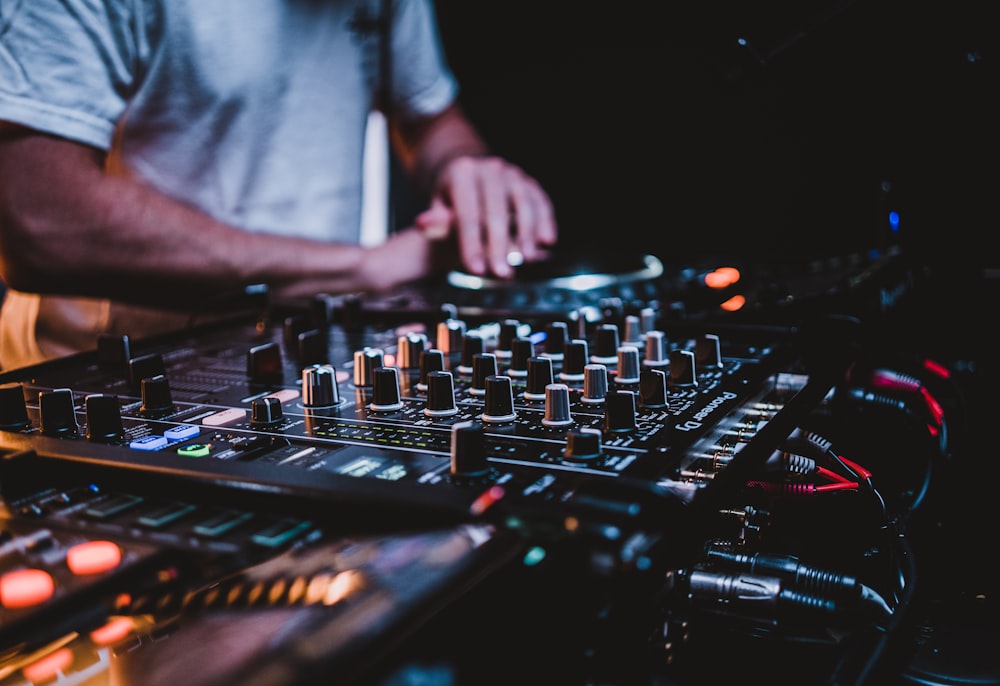 person in gray shirt playing audio mixer