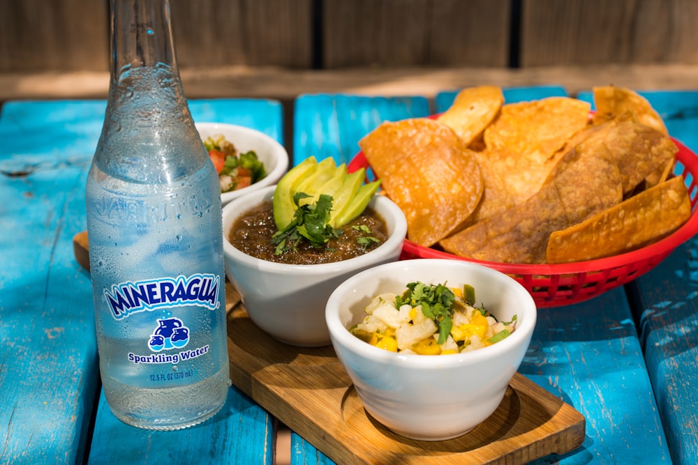 blue and white labeled bottle beside white ceramic bowl with food