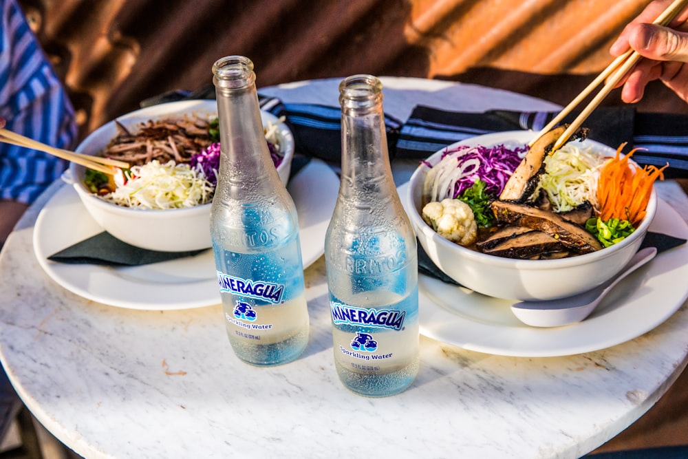 2 blue glass bottles on white table