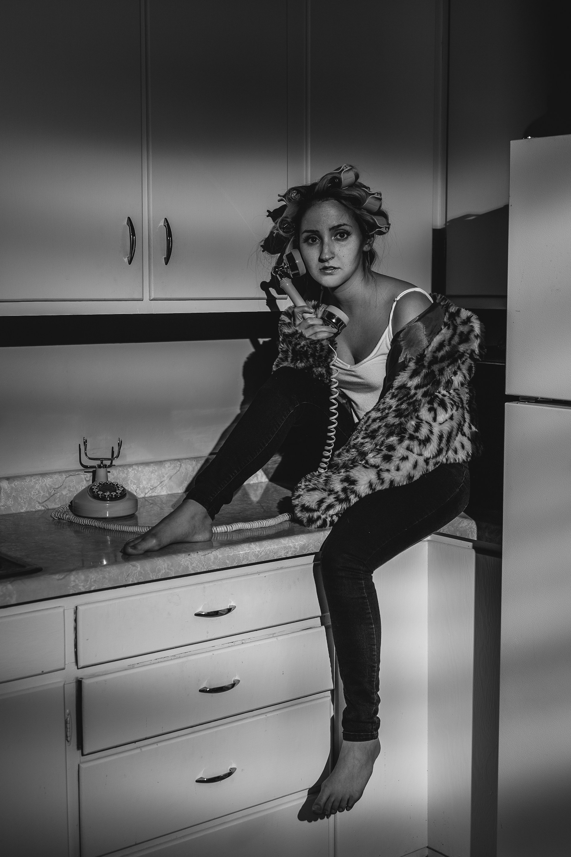 woman in black and white spaghetti strap top and black pants sitting on kitchen sink