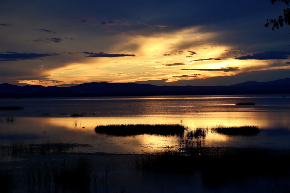 calm water under cloudy sky during sunset