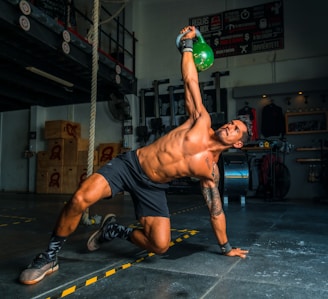 man in black shorts and black tank top doing push up