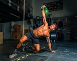 man in black shorts and black tank top doing push up