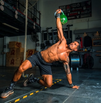 man in black shorts and black tank top doing push up