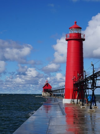 red and white lighthouse near body of water during daytime