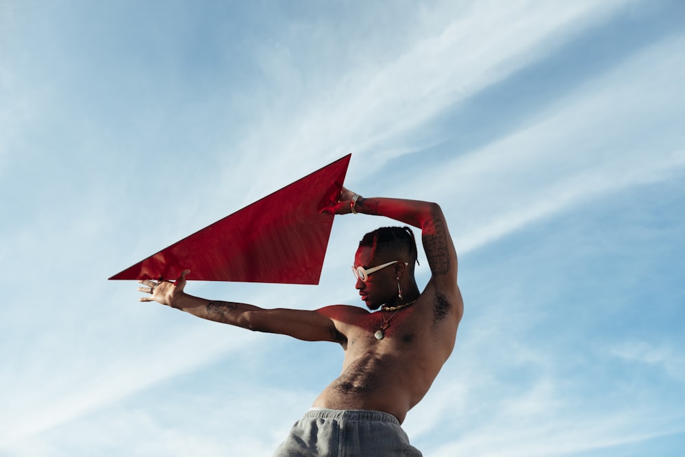 man in blue denim shorts holding red flag