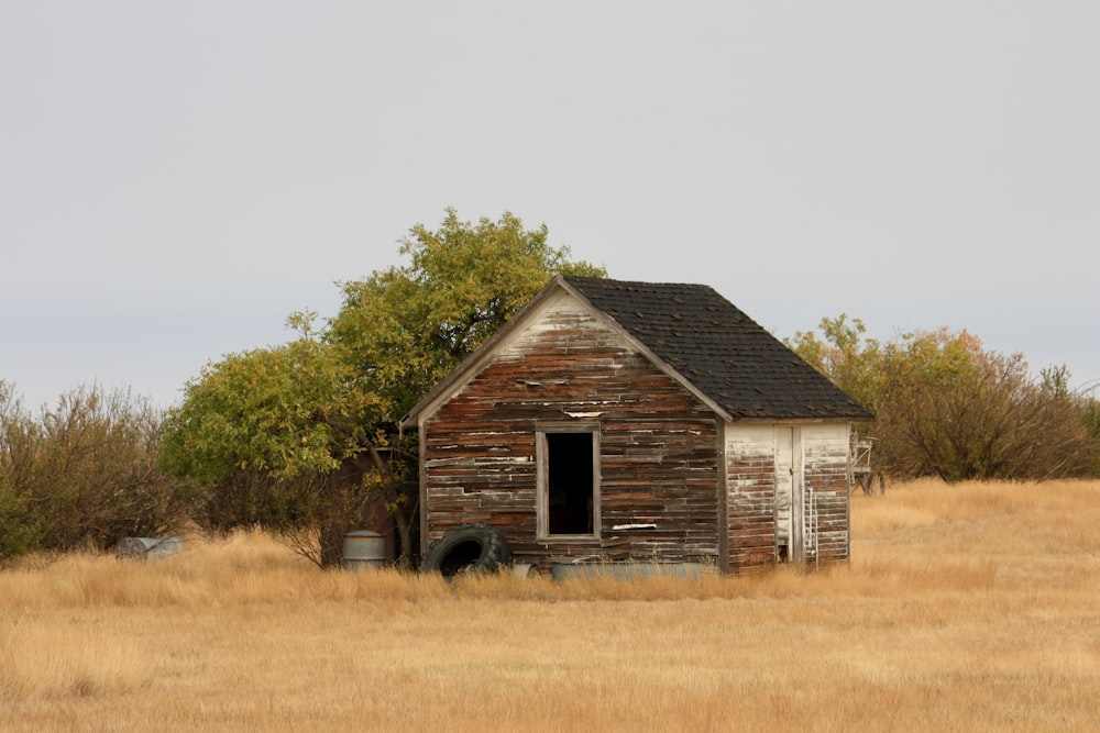 brown wooden house near green trees during daytime