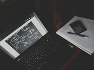 A student practicing exam questions on a laptop in a quiet study space.