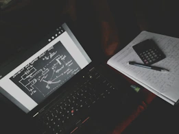 Graphic showing a vibrant biology study session with charts, textbooks, and a laptop.