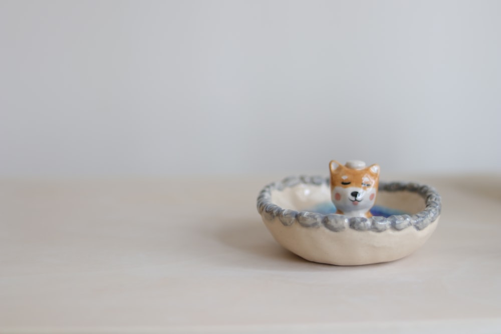 brown and white cat ceramic figurine