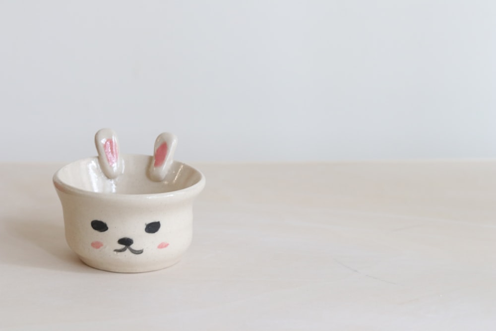 white ceramic mug with white and red ceramic spoons
