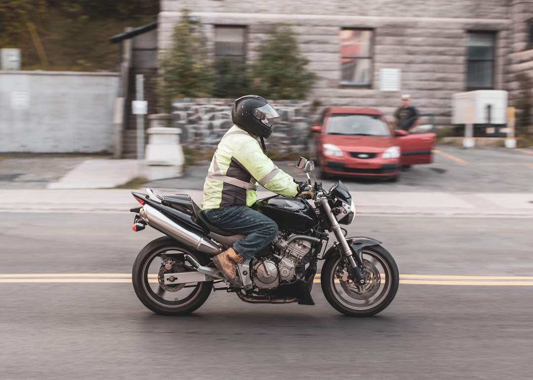 man in white jacket riding motorcycle on road during daytime