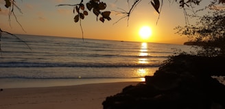 A vibrant sunset over a tranquil beach scene.