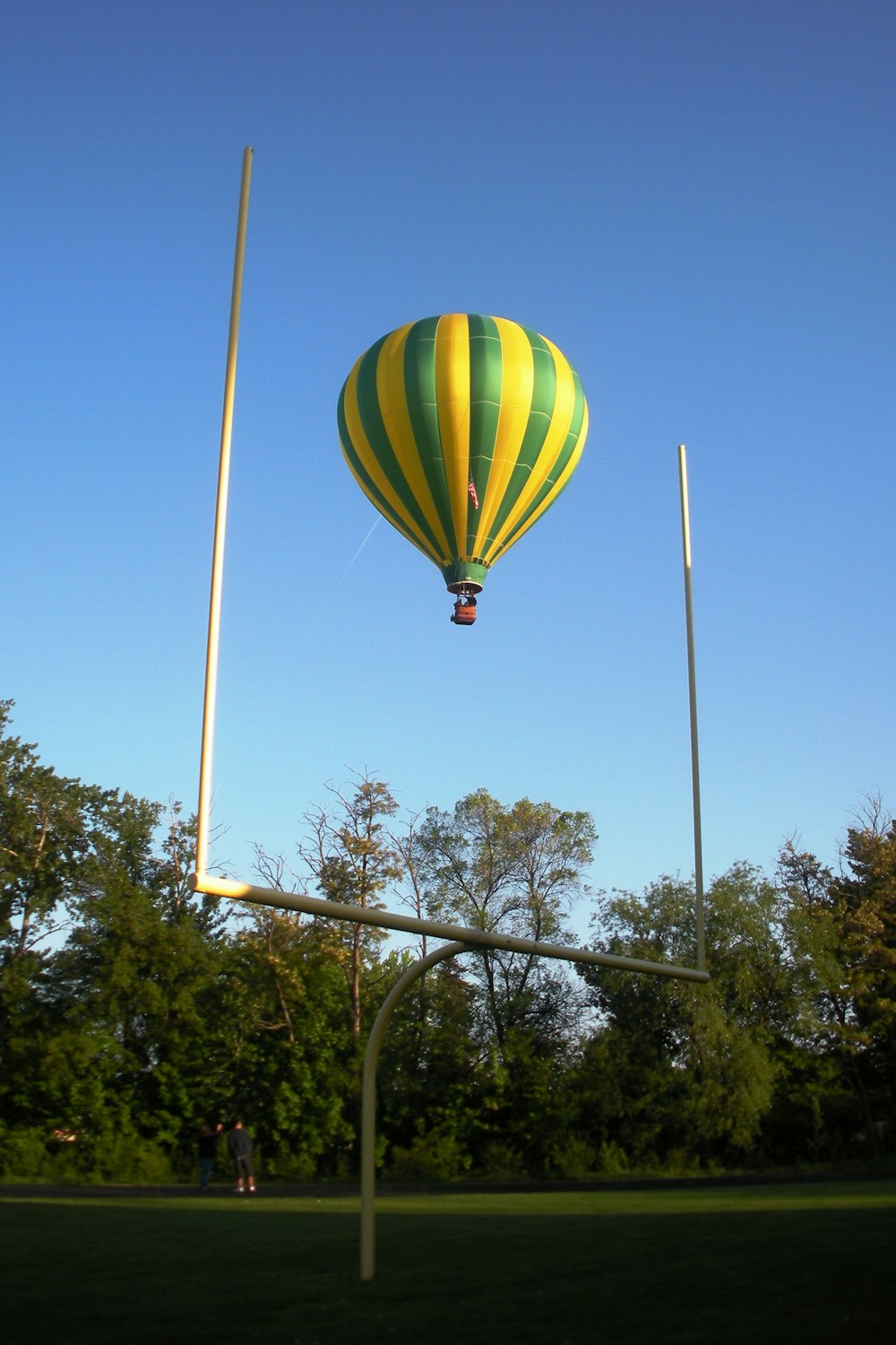 globo aerostático verde, amarillo y azul en el aire durante el día