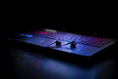 Close-up of headphones resting on a keyboard with soft lighting.