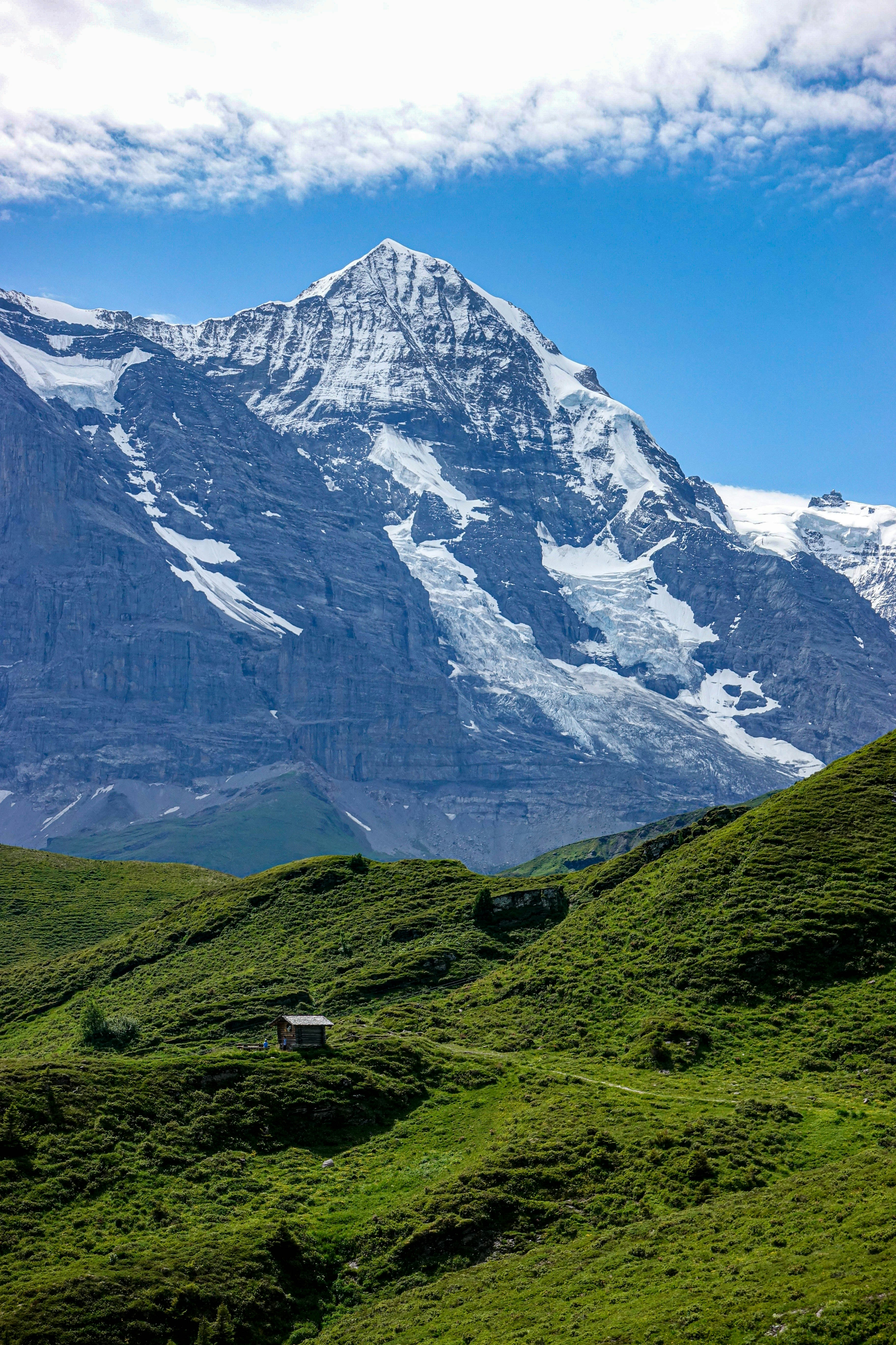 Green Grass Field Near Snow Covered Mountain During Daytime Photo Free Blue Image On Unsplash