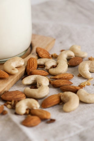 Close-up of fresh cashew nuts and almonds neatly arranged in wooden crates in a warehouse.