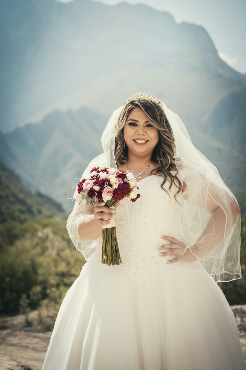 woman in white wedding dress holding bouquet of flowers