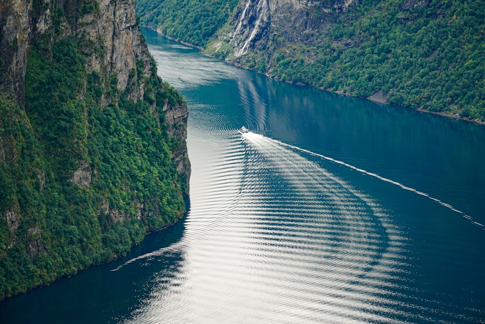 body of water between green mountains during daytime