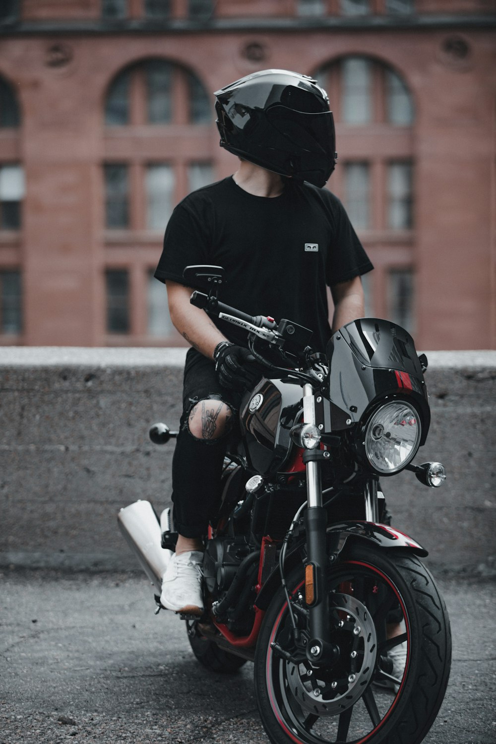 man in black crew neck t-shirt riding black motorcycle during daytime