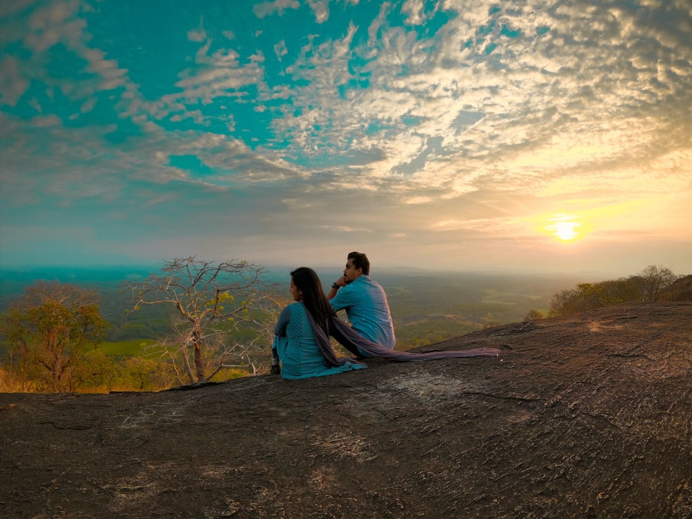 Hombre y mujer sentados en el camino de tierra marrón durante el día
