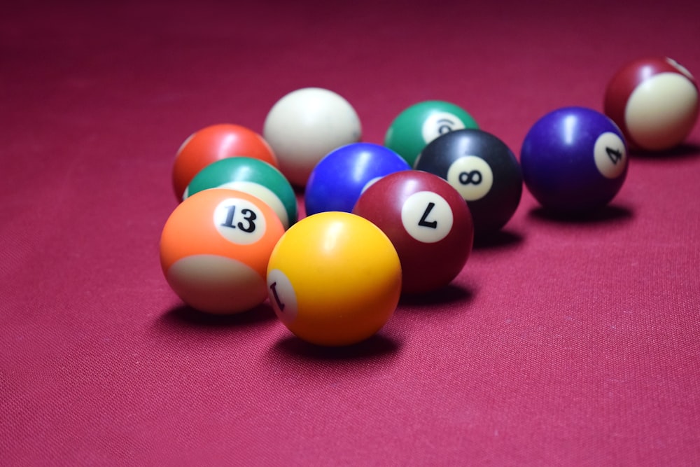 billiard balls lined up in a row on a pink surface