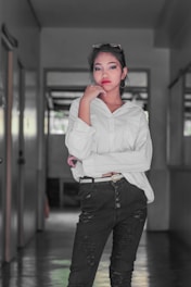 Model wearing a white and black oversized t-shirt with red accents, standing confidently in a raw street setting.