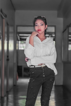 Model wearing a white and black oversized t-shirt with red accents, standing confidently in a raw street setting.
