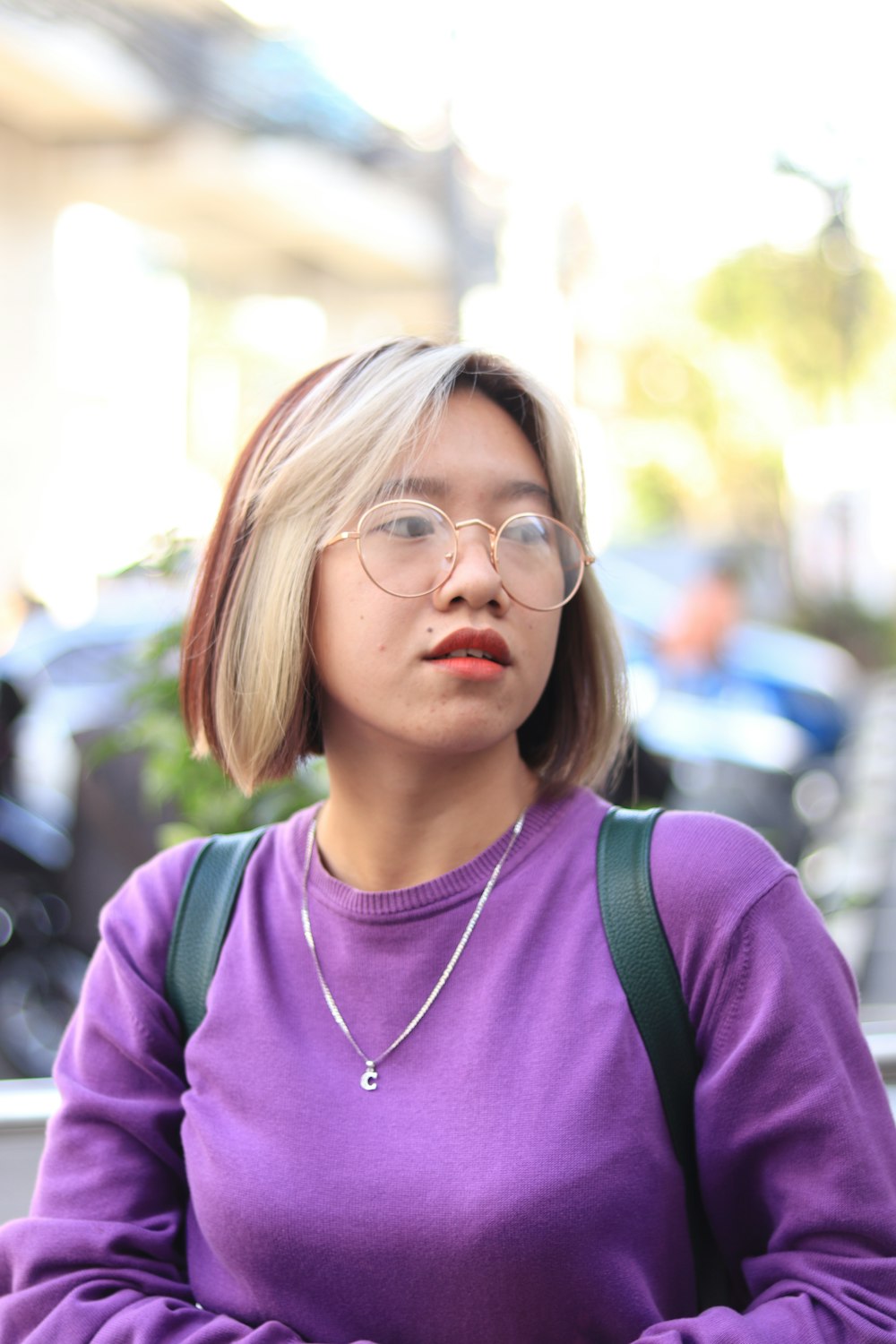 a woman with glasses and a purple shirt