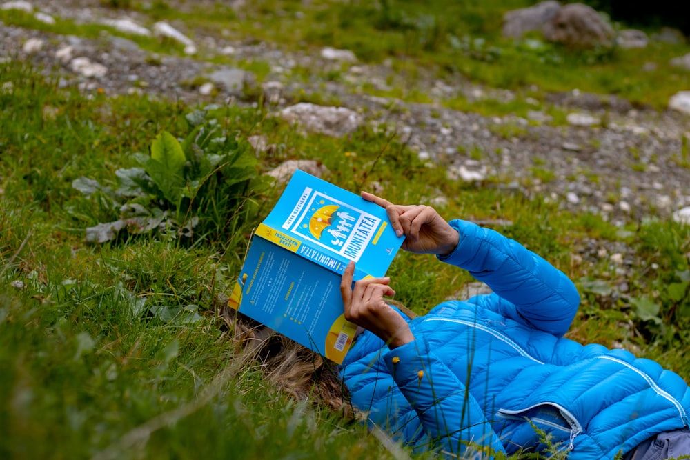 person in blue jacket holding blue and white box