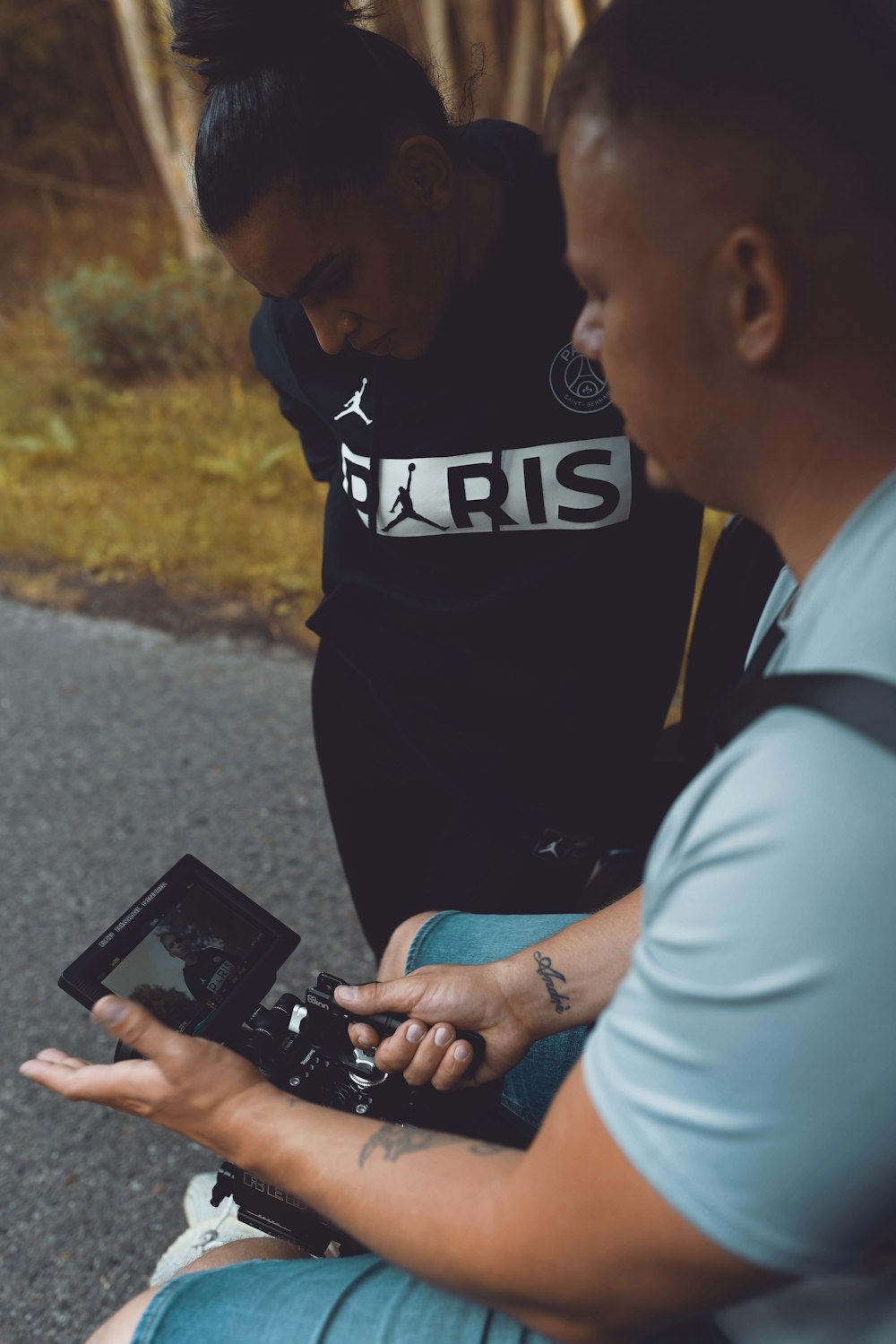 man in black and white hoodie holding black smartphone