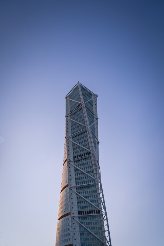 gray concrete building under blue sky during daytime in Turning Torso Building Sweden