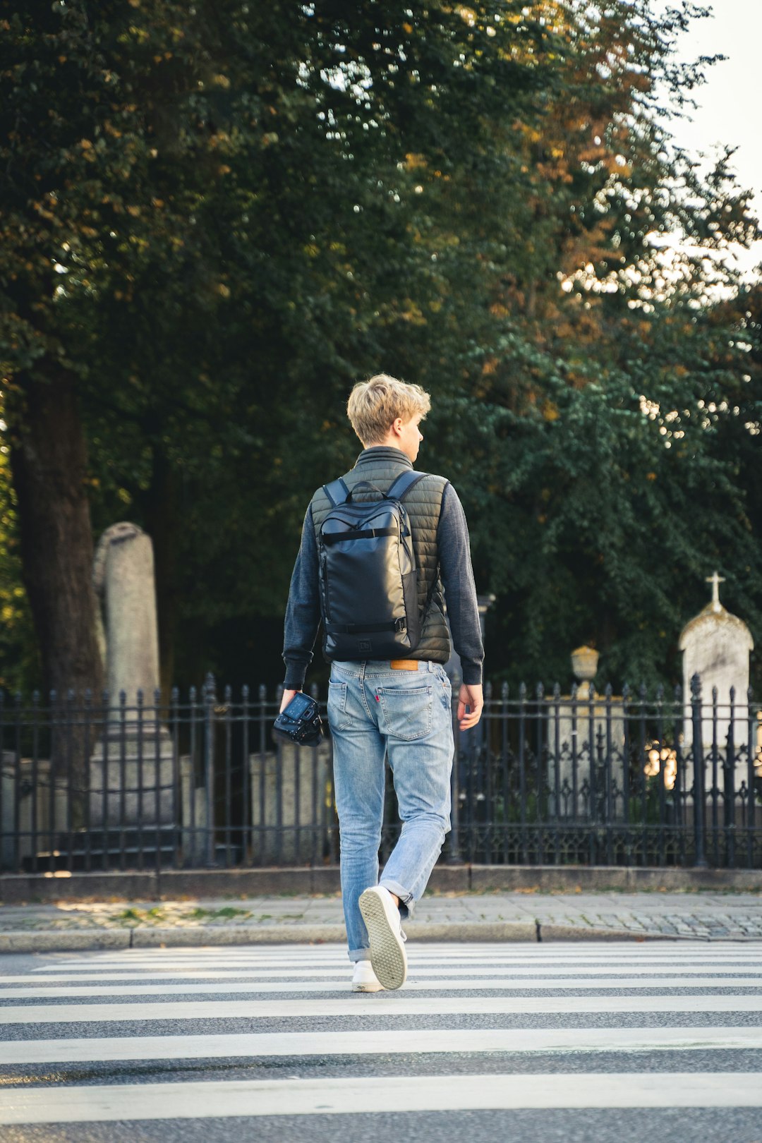 man in blue denim jacket and blue denim jeans walking on sidewalk during daytime