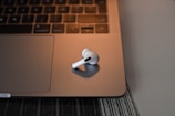 Wireless headphones resting on a modern desk beside a laptop.