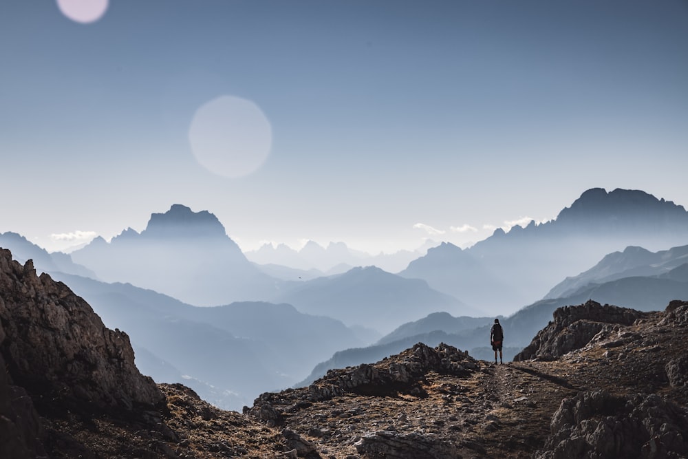 person standing on rocky mountain during daytime