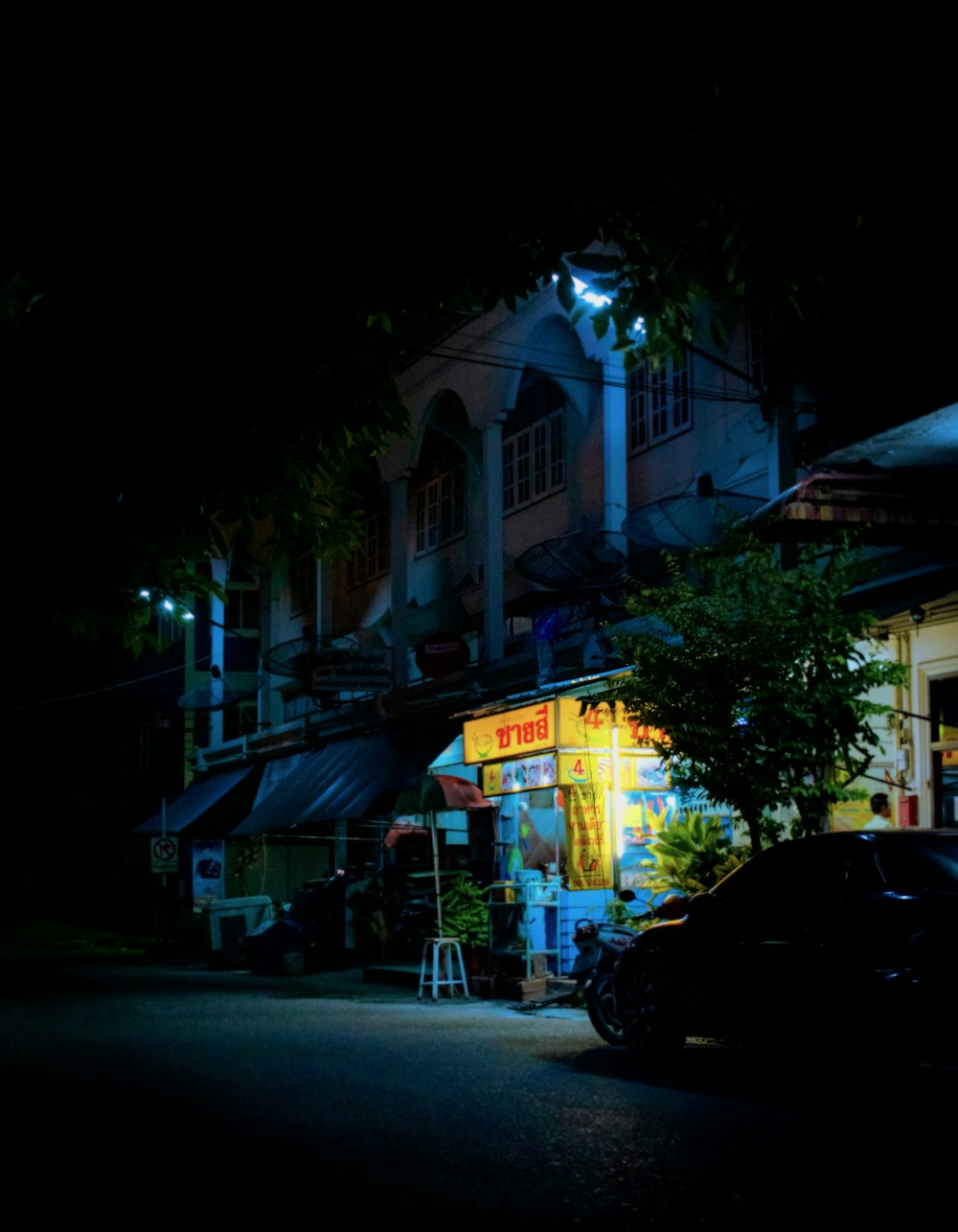 carros estacionados em frente à loja durante a noite
