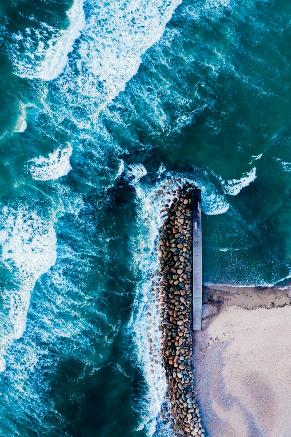 Vue aérienne des vagues de la mer s’écrasant sur le rivage pendant la journée