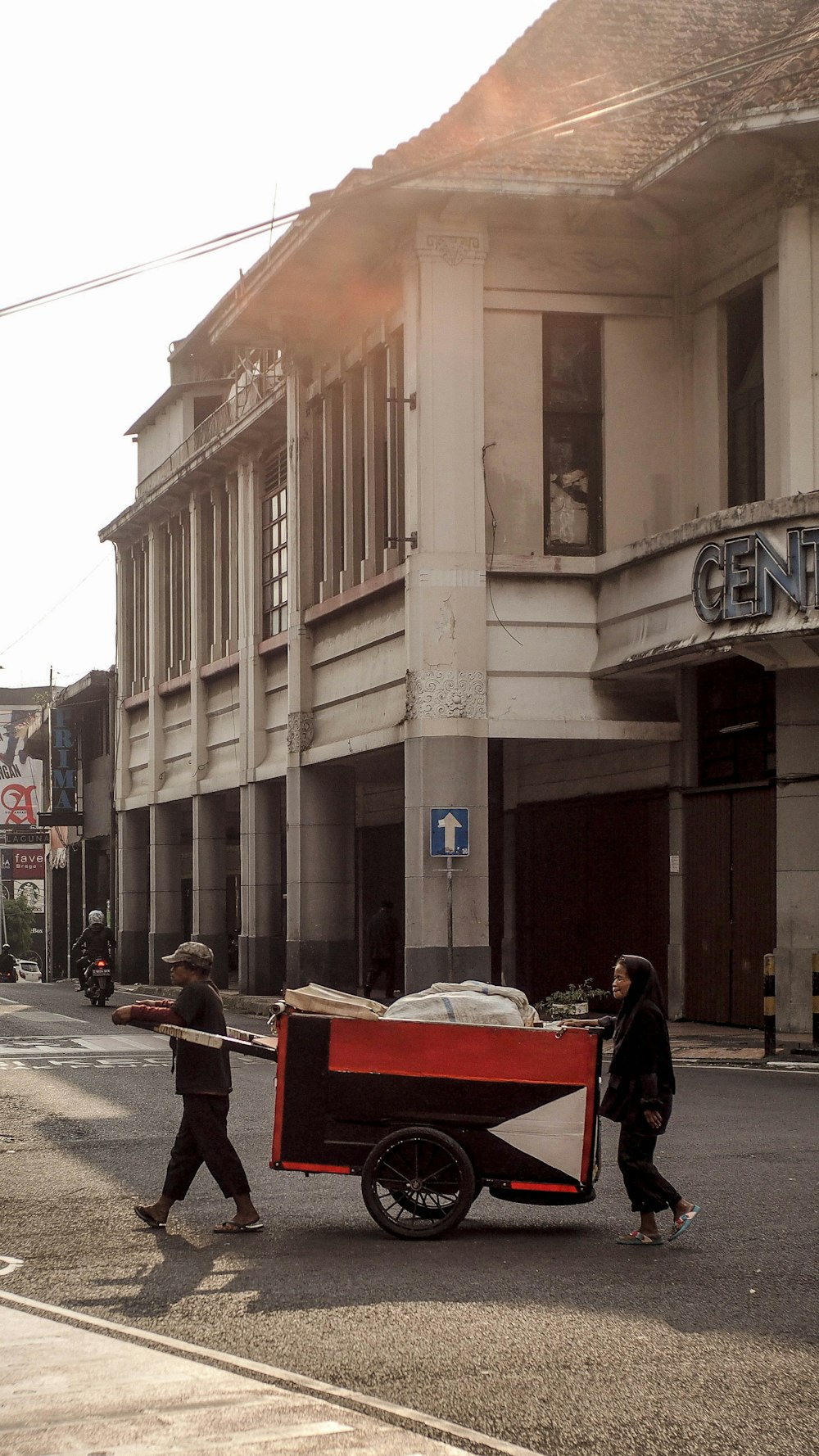 personnes marchant sur le trottoir près d’un bâtiment en béton brun pendant la journée