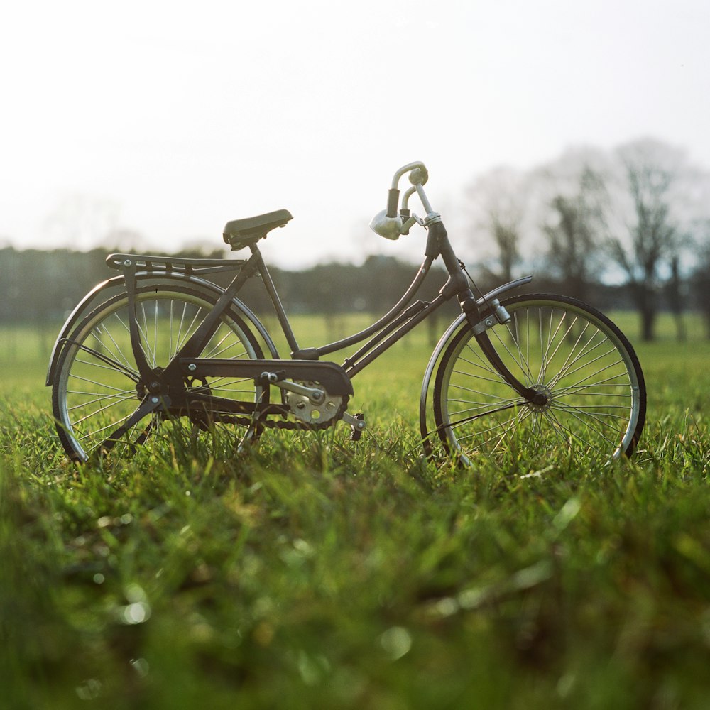 black city bike on green grass field during daytime