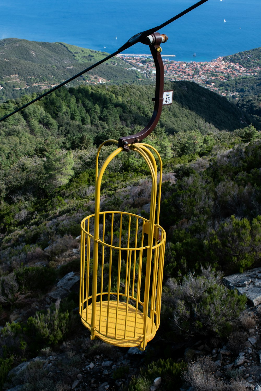 yellow cable car over green mountain during daytime