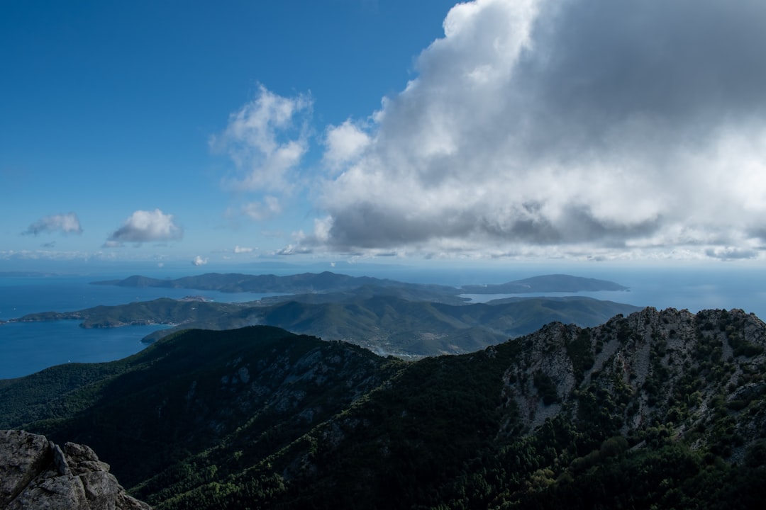 green mountains under blue sky and white clouds during daytime