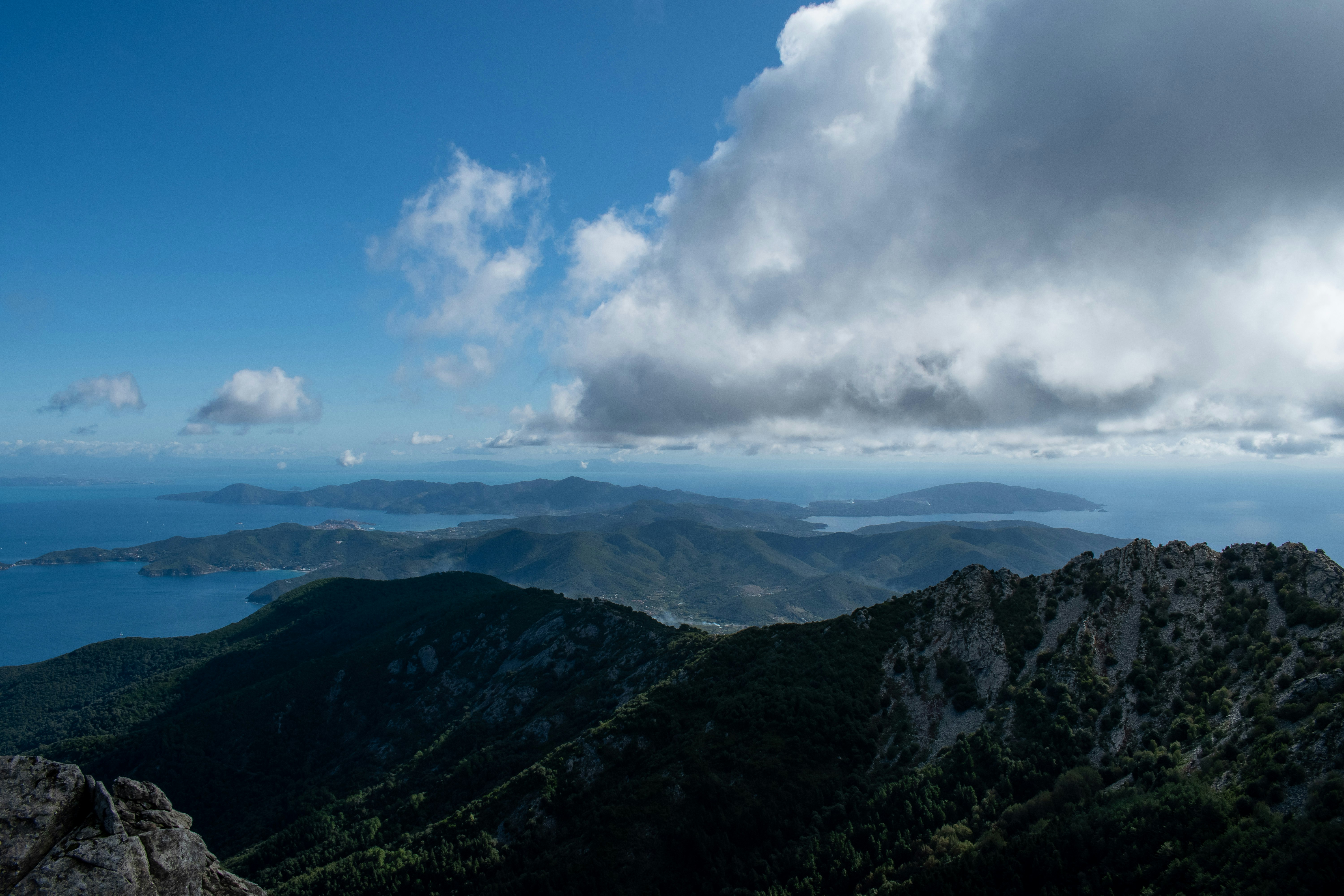 green mountains under blue sky and white clouds during daytime