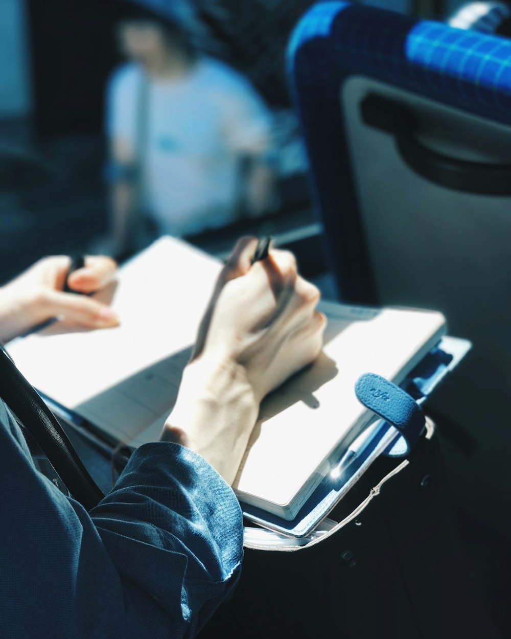 person in blue denim jeans holding white paper