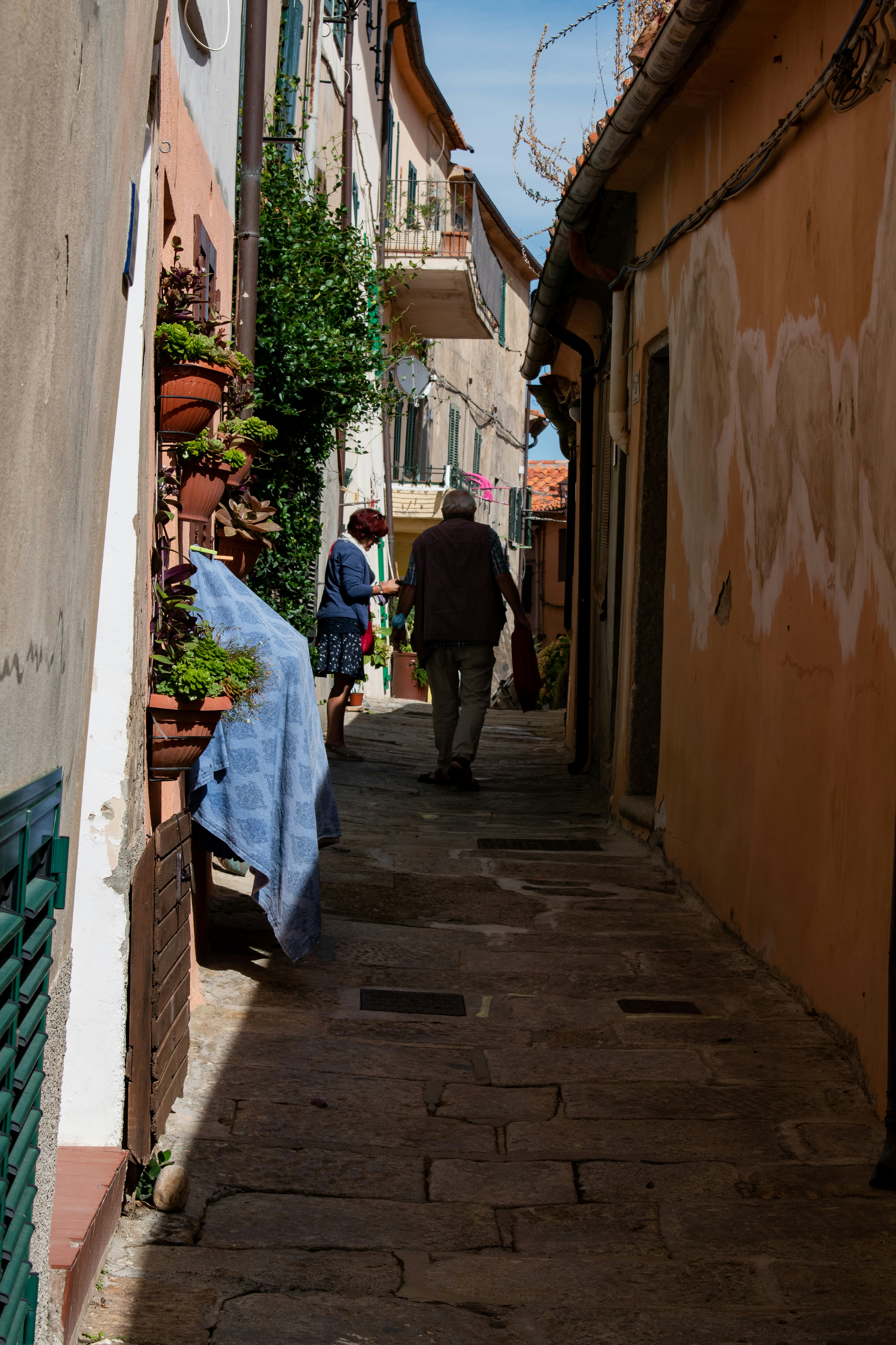 man in black suit walking on sidewalk during daytime